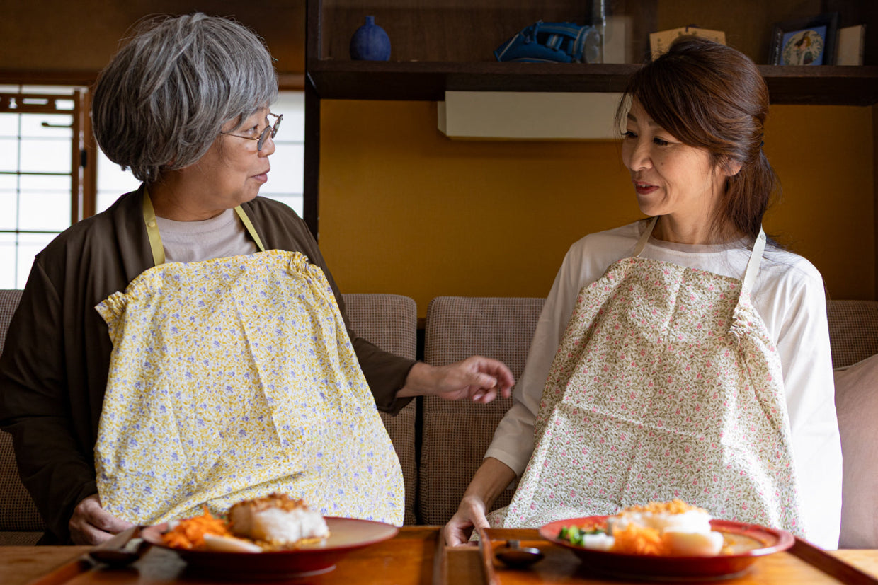 カレーを食べる前に食べこぼしから服を守るエプロンになるハンカチ「布帛の騎士」をつけている親子が笑顔の写真